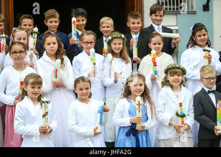 NANDLSTADT, GERMANY - MAY 7, 2017 : A group of young girls and boys holding candles lined up and posing for photographing at their first communion in Stock Photo