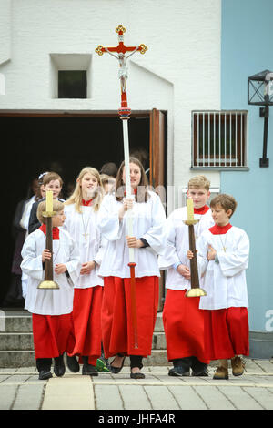 NANDLSTADT, GERMANY - MAY 7, 2017 : A group of altar servers holding candles on stands and leading the communicants at the first communion in Nandlsta Stock Photo