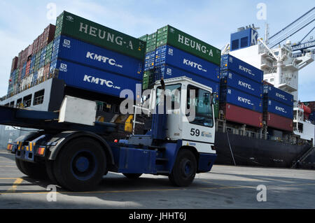Jakarta, Indonesia - May 6, 2017: Container trucks passed between stacks of containers at the Port of Tanjung Priok, Jakarta. Stock Photo