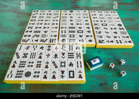 Mahjong '麻將' tiles set on green wooden background Stock Photo