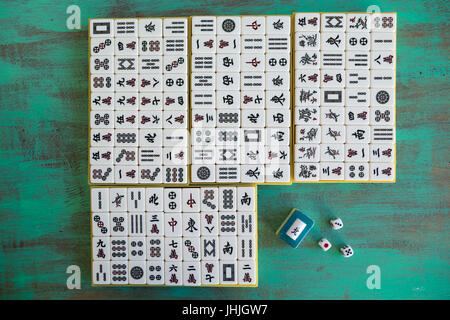 Mahjong '麻將' tiles set on green wooden background, flat lay Stock Photo