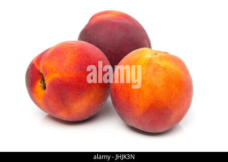 Three uncut, whole, ripe peaches fruit over white background Stock Photo