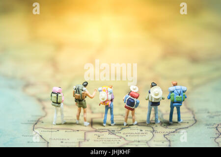Selective focus. Miniature people : small traveler figures with backpack standing on South Africa Map / Geography of South Africa, exploring on earth  Stock Photo