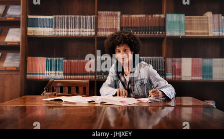 African University student preparing for exams in library. Young college student doing homework in library. Stock Photo