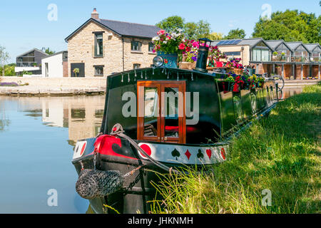 Flowers on a narrow boat on the Grand Union Canal at Marsworth, moored at the Marsworth Wharf contemporary housing development Stock Photo