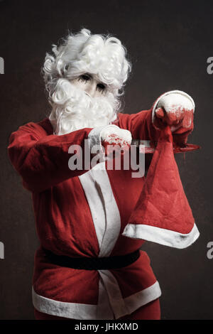Evil Santa Claus cut with bloody knife his christmas hat Stock Photo