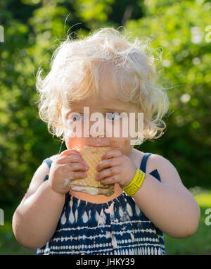 Blond girl eating ice cream, Pembrokeshire, United Kingdom Stock Photo