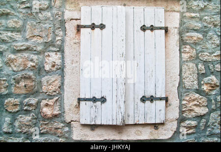 white shutters and medieval stone wall on old town of Budva, Montenegro Stock Photo