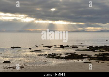 Evening sunlight breaks through dark clouds over the Dornoch firth at Portmahomack in Easter Ross, Scotland. Stock Photo