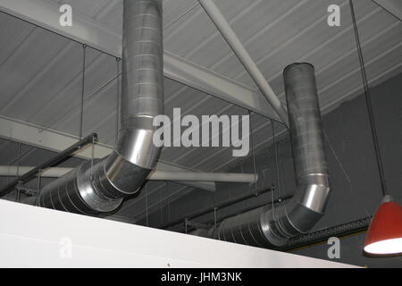 Large profile duct ducting ventilation pipe extraction in shed warehouse building re heating air exchange piping industrial insulated roof space Stock Photo