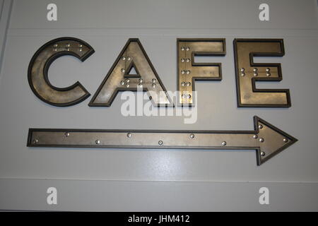 Large metal letters direction sign and arrow pointing to cafe re indoor cafe sign re eating and drinking re socialising meeting friends Stock Photo