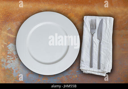 Empty plate with cutlery on rusty steel background. Stock Photo