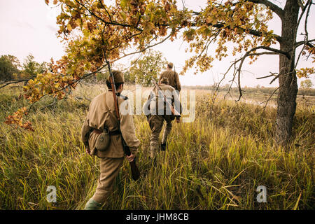 Group Of Reenactors Men Dressed As Russian Soviet Red Army Infantry Soldiers Of World War II Marching In Autumn Forest With Weapons At Historical Reen Stock Photo