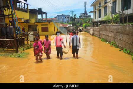 Dimapur, India. 14th July, 2017.  Indian residents wade through wade through flooded street after a heavy rainfall in Dimapur, India north eastern state of Nagaland. The South west monsoon which usually hits the South East Asia region from June till September causes massive flood disaster every year. Credit: Caisii Mao/Alamy Live News Stock Photo