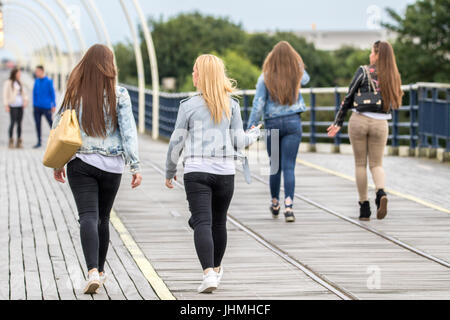 Southport, Merseyside, 14th July 2017. UK Weather.   A much cooler grey evening doesn't stop tourists heading to the pier and seafront at Southport in Merseyside.  With heavy rain downpours expected people were eager to make the most of the dry weather before the rain arrives.   Credit: Cernan Elias/Alamy Live News Stock Photo