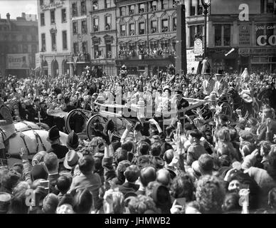 The scene at Ludgate Circus, London, as King George VI and Queen Elizabeth wave to well wishers as they make their way to St. Paul's Cathedral to celebrate their silver wedding anniversary. Stock Photo