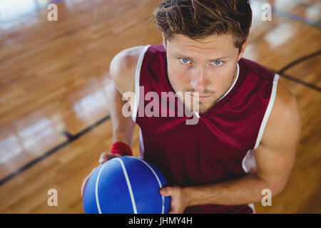 High angle portrait of basketball player holding ball while practicing in court Stock Photo