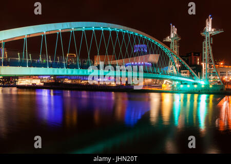 Bridge Over Salford Quays And MediaCityUK Buildings At Night, Manchester, United Kingdom Stock Photo
