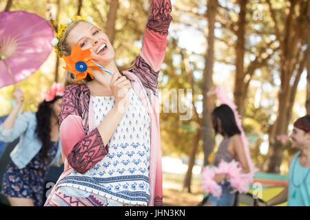 Portrait of happy woman holding pinwheel while enjoying at campsite Stock Photo