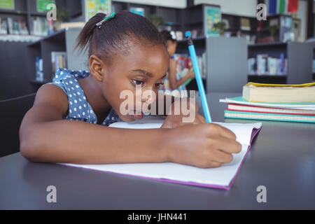 Close up of girl studying at desk in library Stock Photo