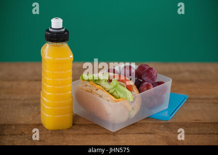 Close-up of tiffin box with fruit and sandwich on table Stock Photo