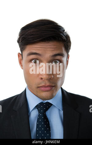 Portrait of young businessman with raised eyebrows against white background Stock Photo