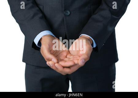 Midsection of businessman with hands cupped standing against white background Stock Photo