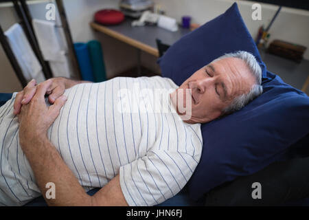 High angle view of senior man sleeping on bed in hospital ward Stock Photo