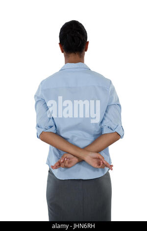 Rear view of businesswoman holding her fingers crossed behind her back