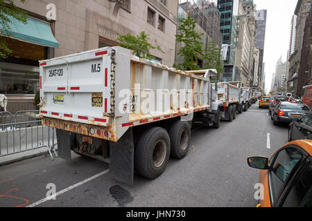 line of construction trucks filled with sand as defences outside trump tower on fifth avenue midtown New York City USA Stock Photo