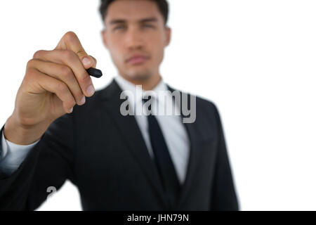 Businessman writing on invisible interface against white background Stock Photo