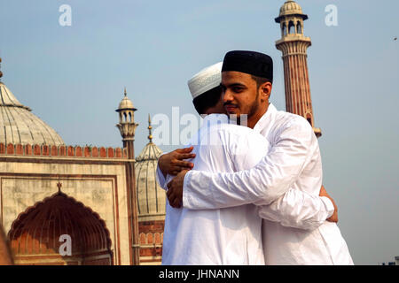 Two muslim men with happy smiley faces celebrating islamic festival eid ul fitr the festival of love and joy and wishing by hugging to each other Stock Photo