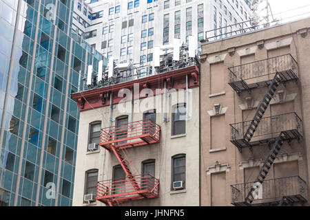 Cellphone antennas on a low-rise corner apartment building rooftop in midtown east, New York City, NY, United States Stock Photo