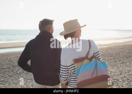 Mature couple looking way on sunset beach Stock Photo