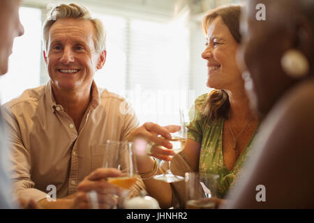 Laughing mature couple drinking wine at restaurant table Stock Photo