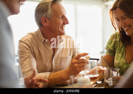Smiling mature couple drinking wine, dining at restaurant table Stock Photo