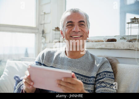 Portrait smiling senior man using digital tablet Stock Photo