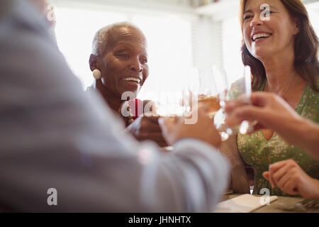 Smiling mature women drinking wine, dining at restaurant Stock Photo