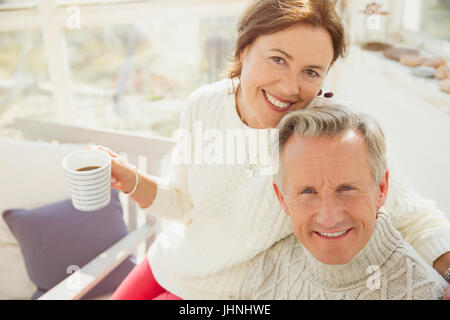 Portrait smiling mature couple hugging and drinking coffee Stock Photo