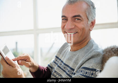 Portrait smiling senior man using digital tablet Stock Photo