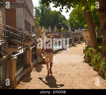 Woman walking through the grounds of the Royal Palace of Aranjuez which  is the spring residence of the Spanish Royal Family near to Madrid Spain Stock Photo