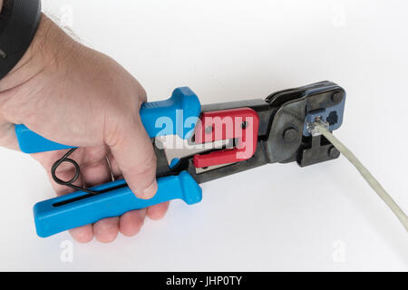 Crimping tool fixing an RJ45 plug to an Ethernet cable Stock Photo