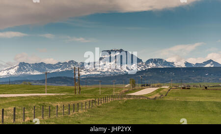 Prairie farmland and wind turbines in the shadow of the Rocky Mountains Alberta Canada Stock Photo