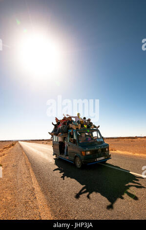people sitting on the roof of the car Stock Photo