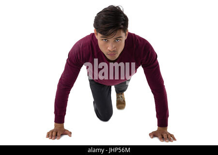 Portrait of businessman doing push ups against white background Stock Photo