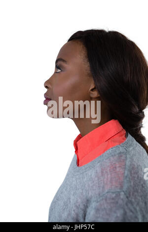 Side view of thoughtful young woman looking up against white background Stock Photo