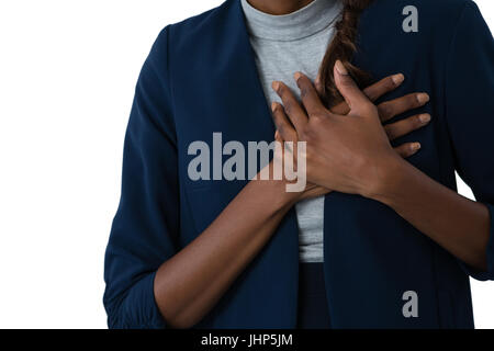 Mid section of woman suffering from chest pain against white background Stock Photo