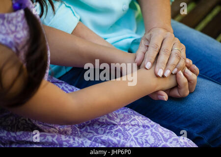 Midsection of senior woman holding hands of grandmother at backyard Stock Photo