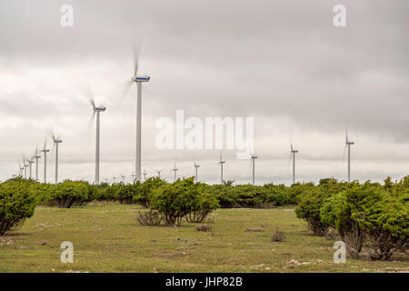 Wind Power Stations Spinning in Green Field. Stock Photo