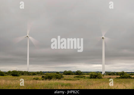 Wind Power Stations Spinning in Green Field. Stock Photo